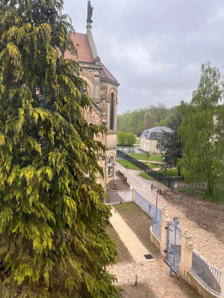 Vue depuis une pièce de l’appartement sur la chapelle historique et le grand sapin de Juilly