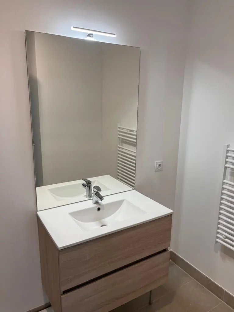 Salle de bain élégante avec lavabo de qualité dans l’appartement restauré à Juilly